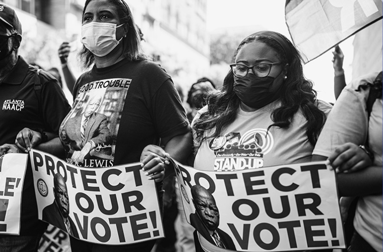 Black women carrying signs that say 