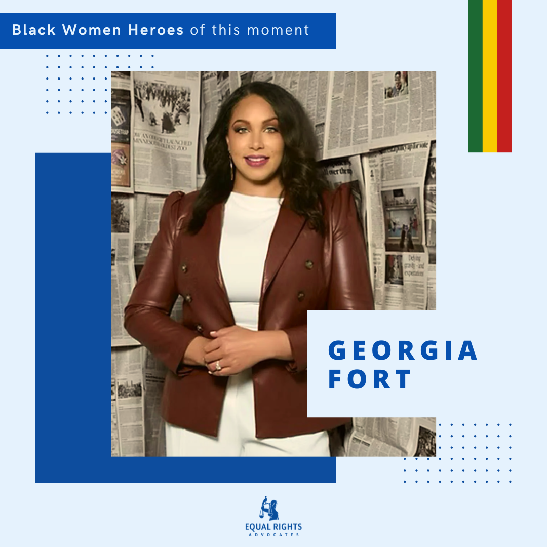 photo of Georgia Fort with labeling for Black History Month. She is wearing a white dress with a bourbon colored leather blazer. She has curly shoulder length brown hair, and her hands are clasped at her waistline. The background appears to be newspapers on a wall.